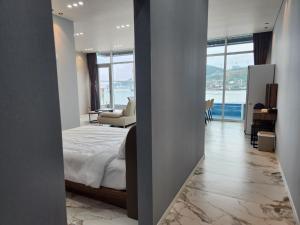 a bedroom with a bed and a view of the ocean at Suite Stay Yeosu in Yeosu