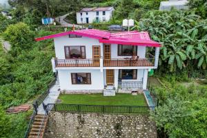 una vista aérea de una casa con techo rosa en SaffronStays Zephyr en Nainital