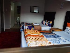 a hotel room with two beds and a television at GALAXY BOSTON BELLVILLE in Cape Town