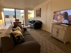 sala de estar con sofá y TV de pantalla grande en Flip Flops Villa two rooms, en Yzerfontein