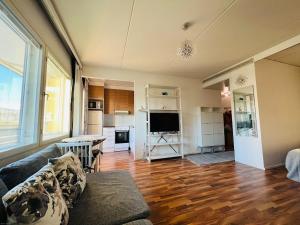 uma sala de estar com um sofá e uma cozinha em Ihana huoneisto meren lähellä. em Helsínquia