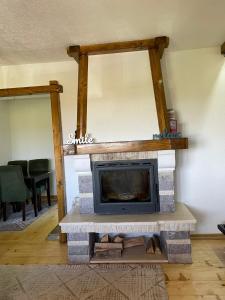 a living room with a stone fireplace with a tv at Eco Village Highlander in Žabljak