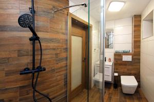 a bathroom with a shower with a wooden wall at Chalet Dereše in Liptovský Mikuláš