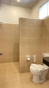 a bathroom with a white toilet and a window at Laemsing Natural Beach Resort in Ban Pak Nam