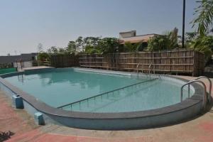 a large swimming pool with a curved track around it at Apna Farmhouse - Private Villa with Pool & Play area - Near Fort -15 min to Ellora Caves in Daulatābād