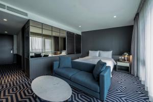 une chambre d'hôtel avec un lit et un canapé bleu dans l'établissement Hotel Marinabay Seoul, à Gimpo