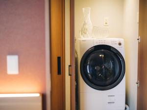 a washing machine with a vase on top of it at MIMARU SUITES KYOTO SHIJO in Kyoto