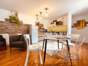a dining room with a table and chairs and a kitchen at L'edelweiss: three-bedroom hypercentre in Saint-Étienne