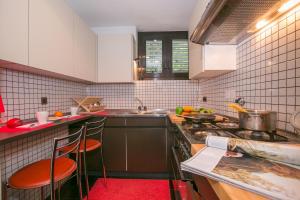 a kitchen with a stove and some chairs in it at Lugano Luxury - Happy Rentals in Lugano
