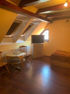 a bedroom with a bed and a table and a tv at Casa Lenke in Săcele