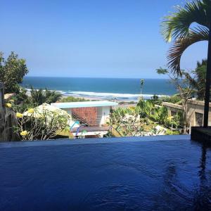 a large swimming pool with a view of the ocean at Villa Alcheringa Yogyakarta in Yogyakarta