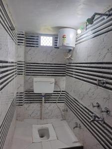 a bathroom with a white toilet in a room at Shree Krishna Hotel in Udaipur
