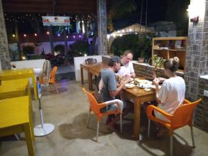 un grupo de personas sentadas en una mesa comiendo comida en The Bavarian Resort, en Arugam Bay