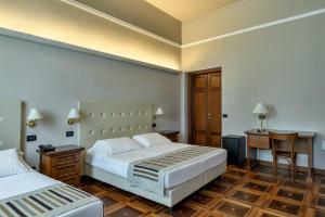 um quarto de hotel com duas camas e uma secretária em Hotel Antica Dimora em Mântua