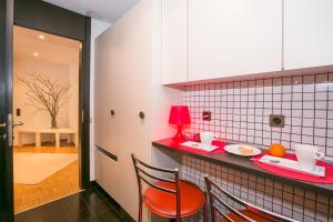 a kitchen with a red counter with a table and chairs at Lugano Luxury - Happy Rentals in Lugano