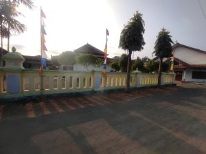 a white fence with flags on top of it at Capital O 93024 Hotel Ganesha in Purworejo