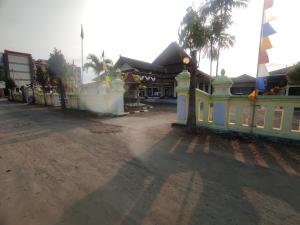 a street with a yellow fence and a building at Capital O 93024 Hotel Ganesha in Purworejo