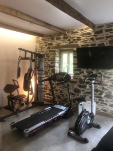 um quarto com um ginásio com duas bicicletas de exercício e uma televisão de ecrã plano em Gite équestre du Dourdu em Lopérec