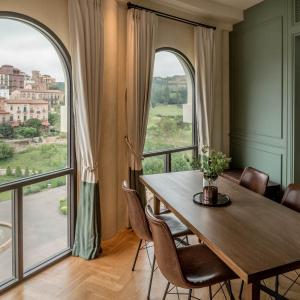 een eetkamer met een tafel en een groot raam bij Toscana Piazza in Mu Si