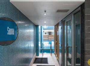 a hallway of a bathroom with blue tiles at Absolute Beachfront at the Pier Glenelg in Adelaide