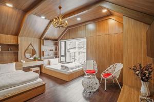 a bedroom with a bed and two chairs in it at VMT Villa in Khu Chi Lăng