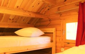 a wooden cabin with two bunk beds and a window at Chalet Ariégeois in Saint-Ybars