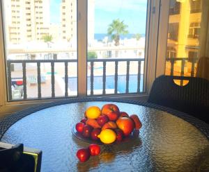 a bowl of fruit on a table with a view of the beach at Spacious apartment La Mata pool&beach in Torrevieja