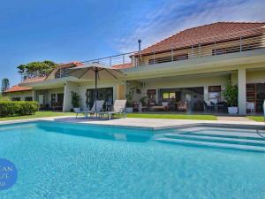 a house with a swimming pool in front of a house at Ocean Gaze Bed and Breakfast in Ramsgate