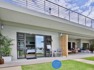 a house with glass doors and a balcony at Ocean Gaze Bed and Breakfast in Ramsgate