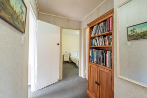 a hallway with a book shelf filled with books at Knights Retreat - Paihia Holiday Home in Paihia