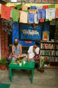 two men sitting at a table in a book store at Nirvana Green Peace Home in Kathmandu
