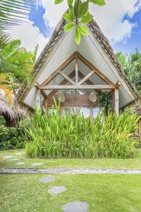 Cette petite maison est dotée d'un toit de chaume. dans l'établissement Ohana Boutique Villa by Hombali, à Canggu