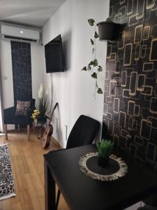 a living room with a table and a guitar at BG apartman in Vrnjačka Banja