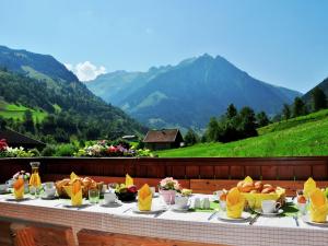 フッシュ・アン・デア・グロックナーシュトラーセにあるLuxury chalet in Fusch an der Grossglocknerstrasse Salzburgerland with saunaの山を背景に食べ物を載せたテーブル