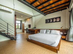 a bedroom with a large bed and a staircase at Gord ChiangMai - SHA Extra Plus in Chiang Mai