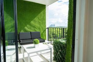 a balcony with a couch and a green wall at Live in style! apartment in North Miami Beach