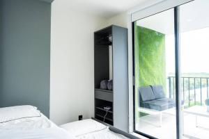 a bedroom with a bed and a window with a chair at Live in style! apartment in North Miami Beach