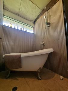uma banheira branca na casa de banho com uma janela em Bears House em Furano