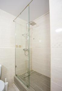 una doccia con porta in vetro in bagno di Domus Hotel ad Aqtau