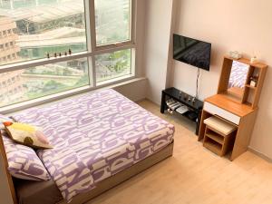 a bedroom with a bed and a tv and a window at Travel House in Seoul