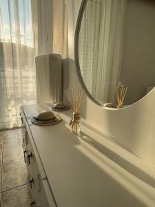 eine Badezimmertheke mit einem Spiegel und einem Waschbecken in der Unterkunft Chris view in Káto Ássos