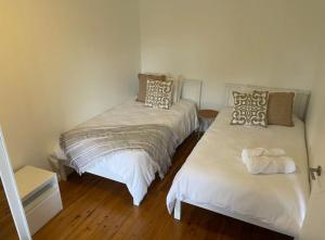 Habitación con 2 camas individuales y suelo de madera. en Copacabana 4 61 Sandy Point Rd - water views, air con and WiFi en Corlette