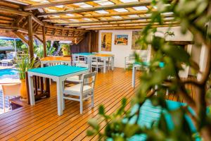 una terraza con mesas y sillas y una piscina en Sandals Guest House, en St Francis Bay