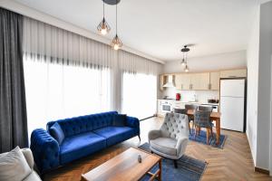 RED MOON SUITES في فتحية: غرفة معيشة مع أريكة زرقاء وطاولة