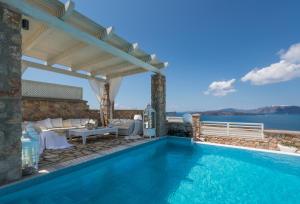 una piscina con pérgola y el océano en Michaela Residence, en Akrotiri