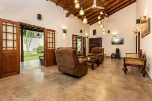 a large living room with chairs and a tv at Villa Diyathra in Tangalle