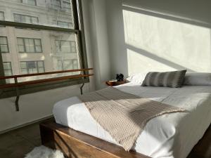 a bedroom with a bed and a large window at Historic Downtown LA Loft - Urban Charm in Los Angeles