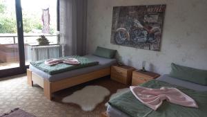 een slaapkamer met twee bedden en een motorfiets aan de muur bij Ferienwohnung Margit in Sulzfeld