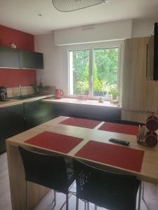 a kitchen with a table with chairs and a window at Campagne à la Ville in Pontivy