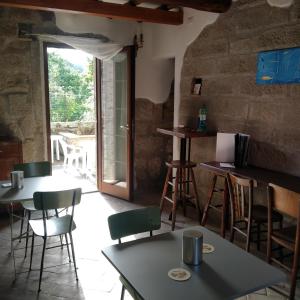 una sala de estar con mesas, sillas y una ventana en La Casa di Augusto, en Bomarzo